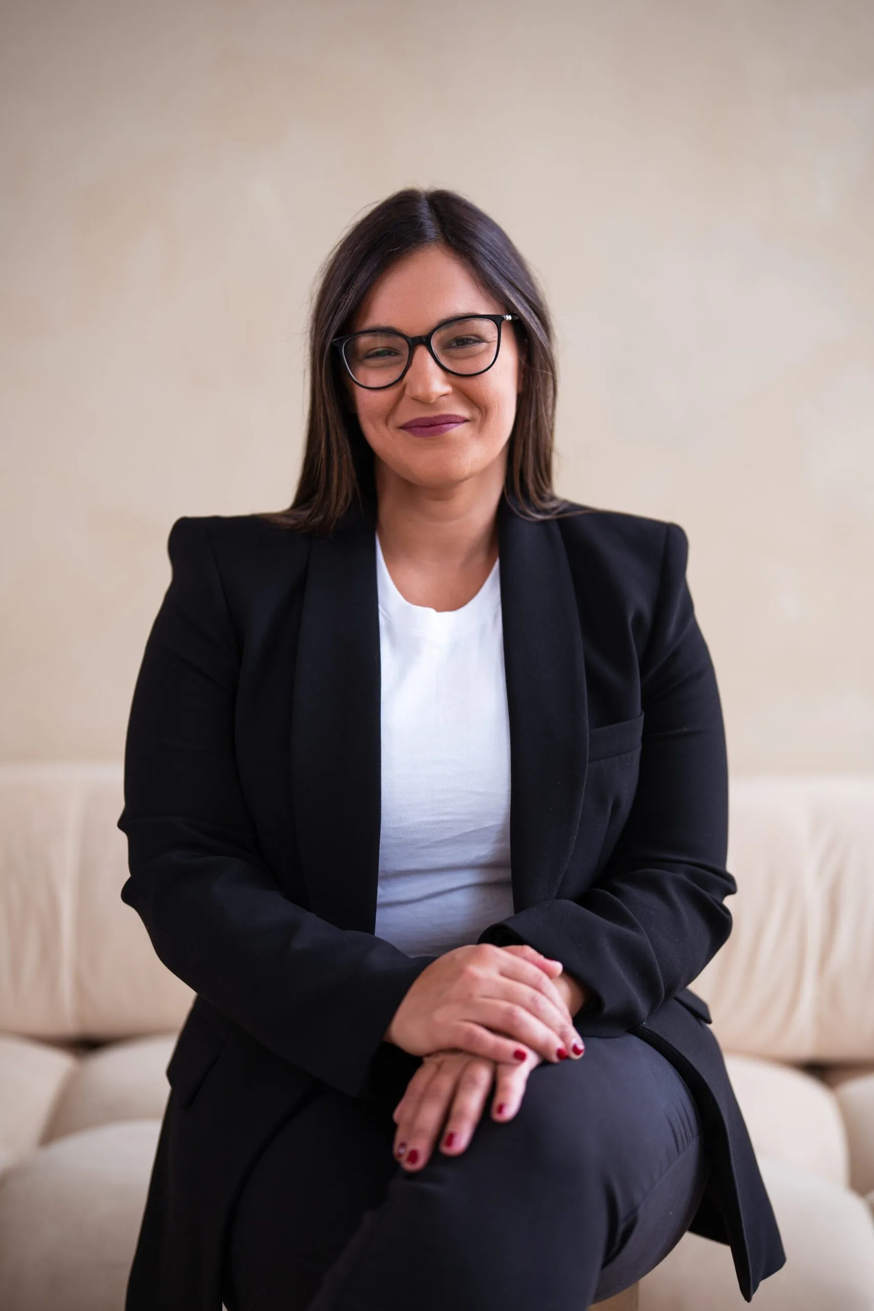 Dr. Andi-Jean Miro, cosmetic dentist at Apa Aesthetic, seated in a black suit